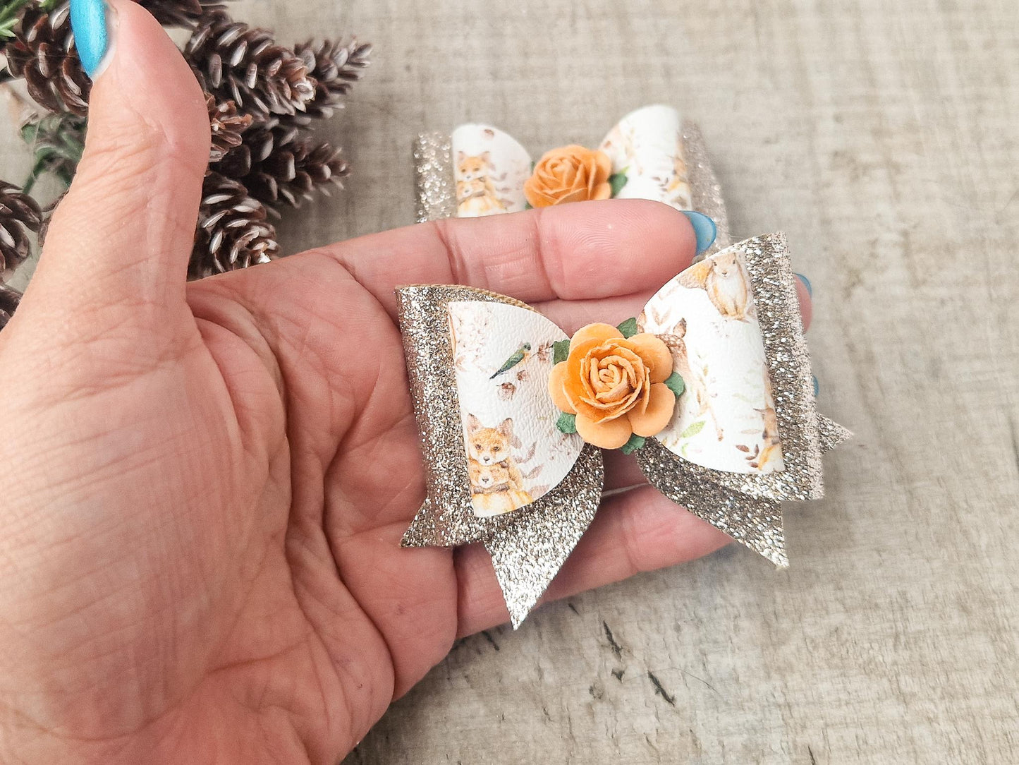 Autumn Hair bow with a Woodland Design and embellished with an orange Flower.