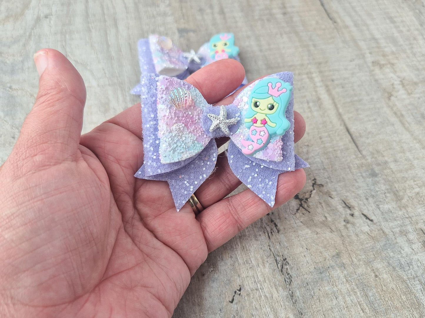 Blue Mermaid Glitter Hair bow embellished with a Mermaid, star fish and sea shell.