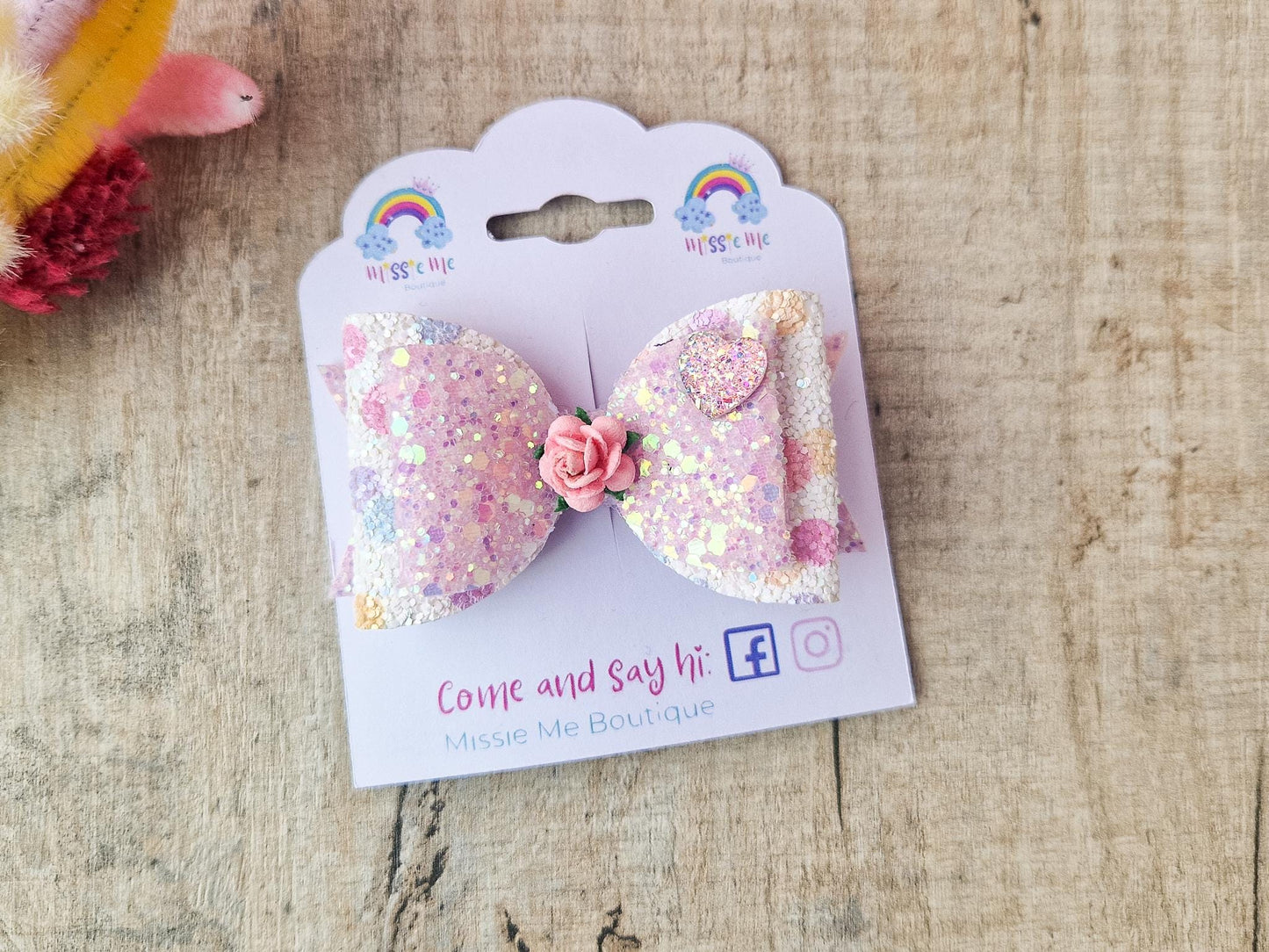 Glitter Hair bow, in pink Pastel glitter colours with a heart and flower Embellishment.