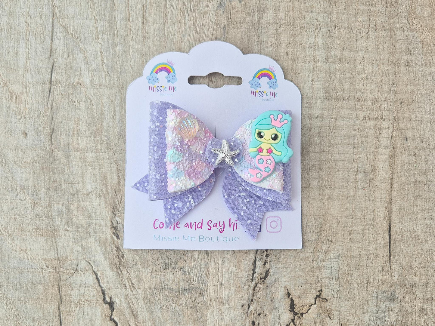 Blue Mermaid Glitter Hair bow embellished with a Mermaid, star fish and sea shell.