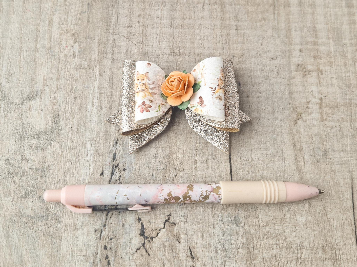 Autumn Hair bow with a Woodland Design and embellished with an orange Flower.