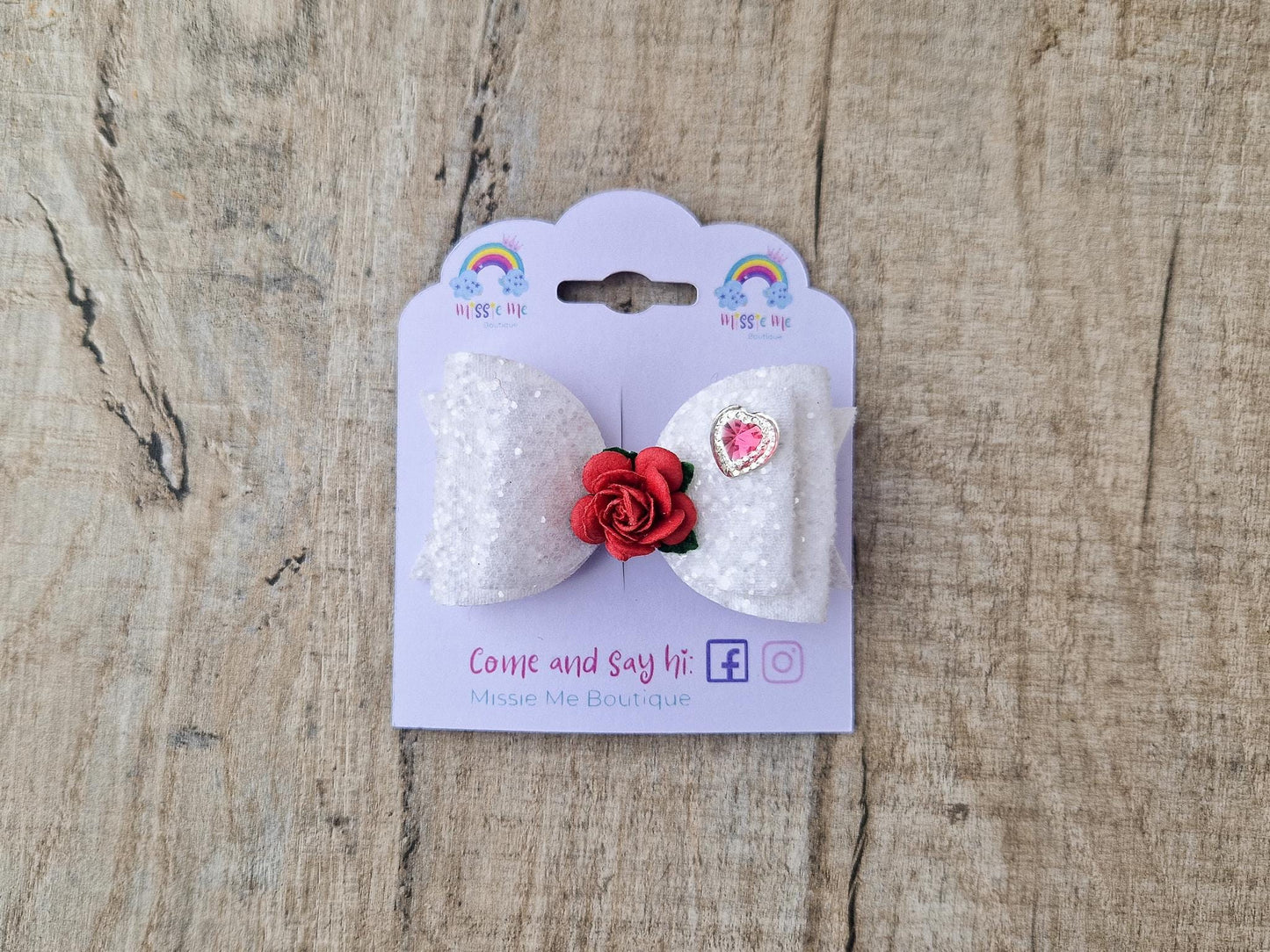 Beautiful Girls hair bow made with white Glitter and finished with a red rose and pink heart embellishment.