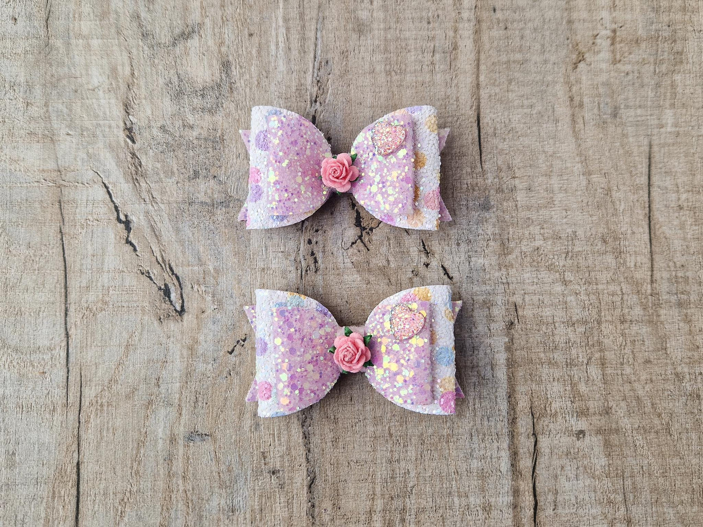 Glitter Hair bow, in pink Pastel glitter colours with a heart and flower Embellishment.