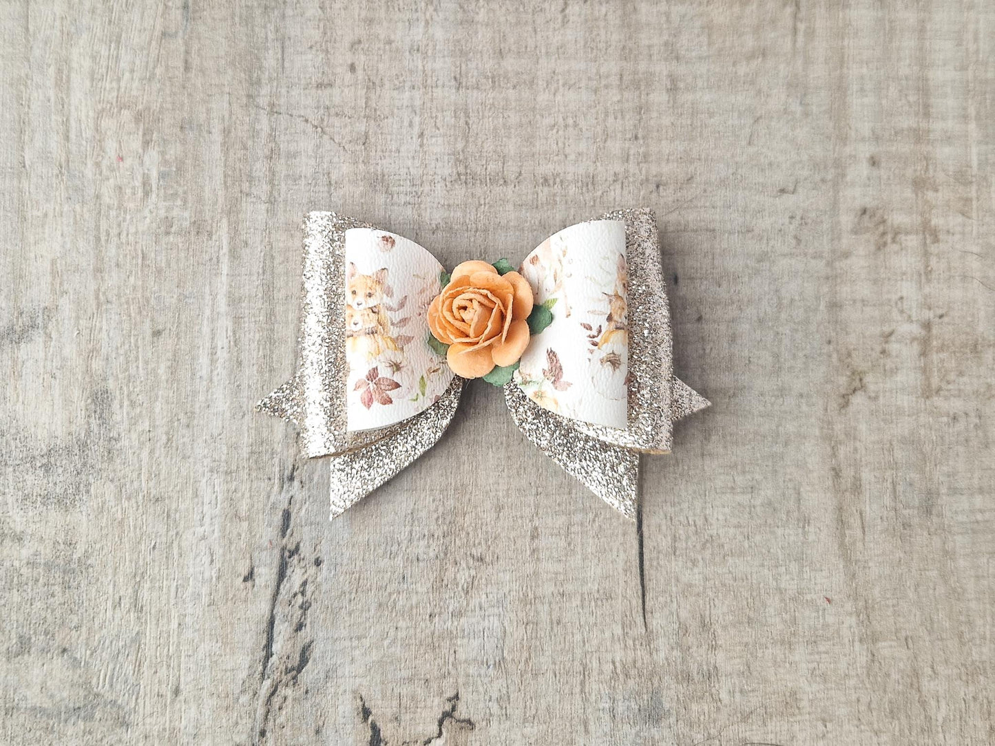 Autumn Hair bow with a Woodland Design and embellished with an orange Flower.