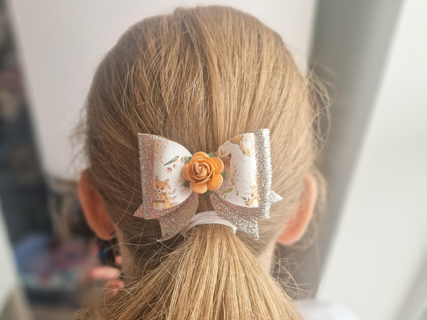 Autumn Hair bow with a Woodland Design and embellished with an orange Flower.