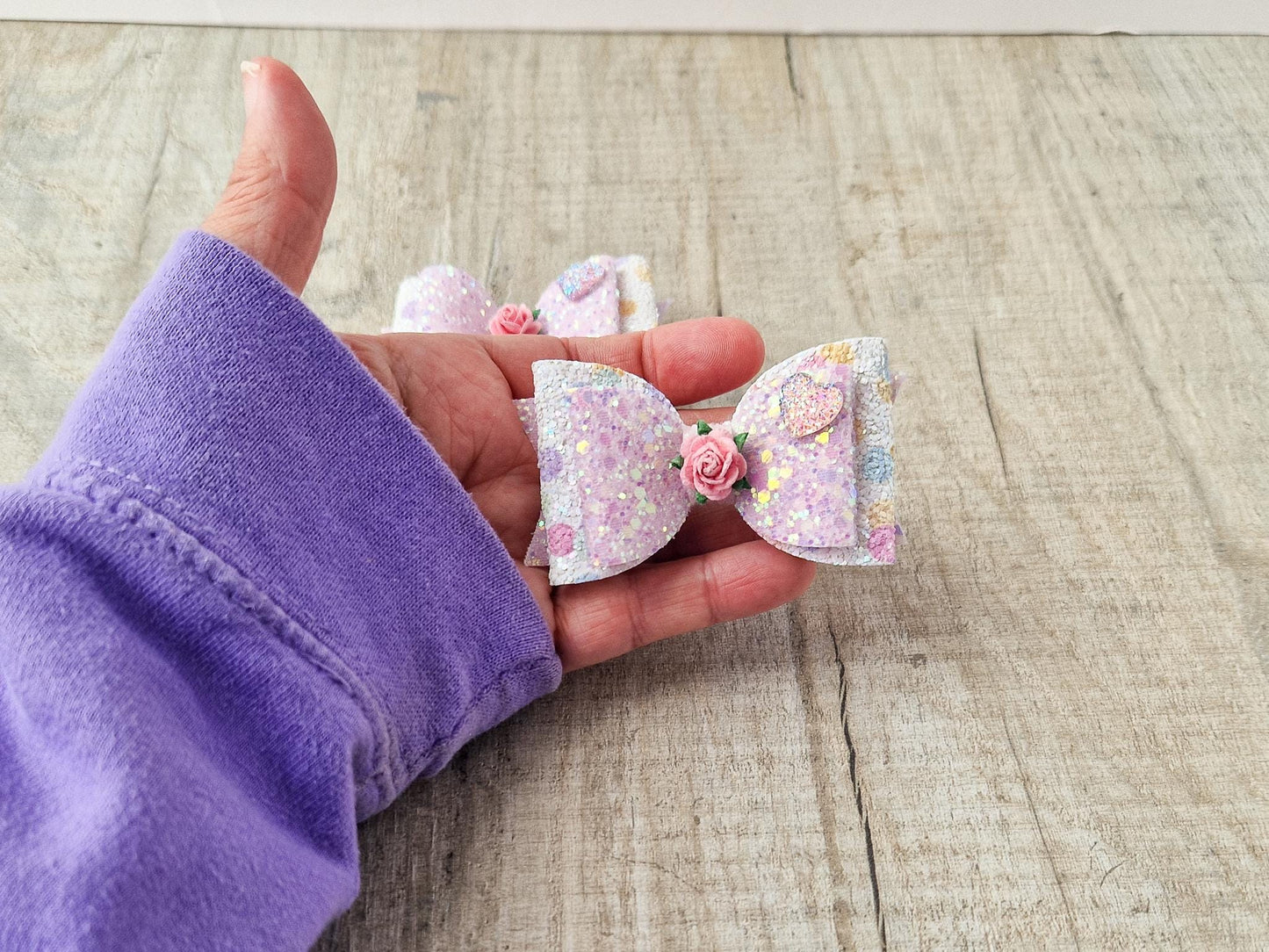 Glitter Hair bow, in pink Pastel glitter colours with a heart and flower Embellishment.