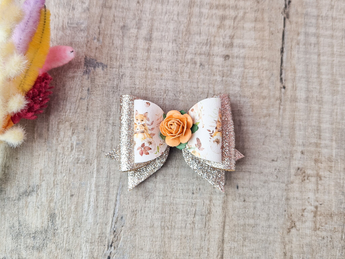 Autumn Hair bow with a Woodland Design and embellished with an orange Flower.