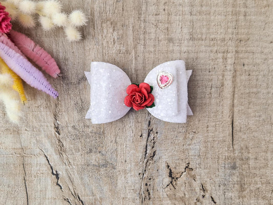 Beautiful Girls hair bow made with white Glitter and finished with a red rose and pink heart embellishment.