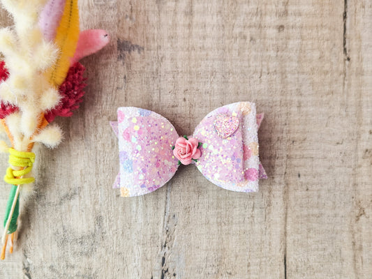 Glitter Hair bow, in pink  Pastel glitter colours with a heart and flower Embellishment.