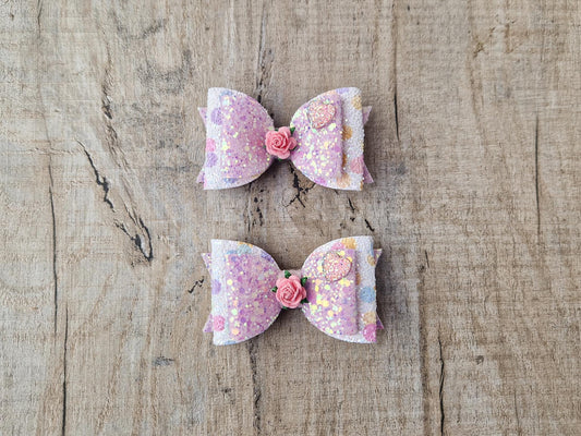 Glitter Hair bow, in pink  Pastel glitter colours with a heart and flower Embellishment.