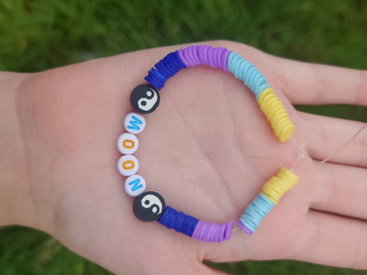 Colorful beaded bracelet on a hand with grass in the background