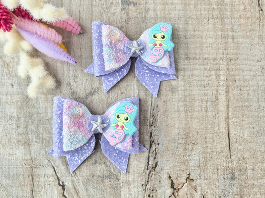 Blue Mermaid Glitter Hair bow embellished with a Mermaid, star fish and sea shell.